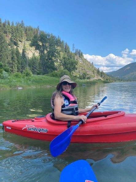 Mary Colas, RN, MHA, the new Surgery Manager sitting in a kayak out on the water.